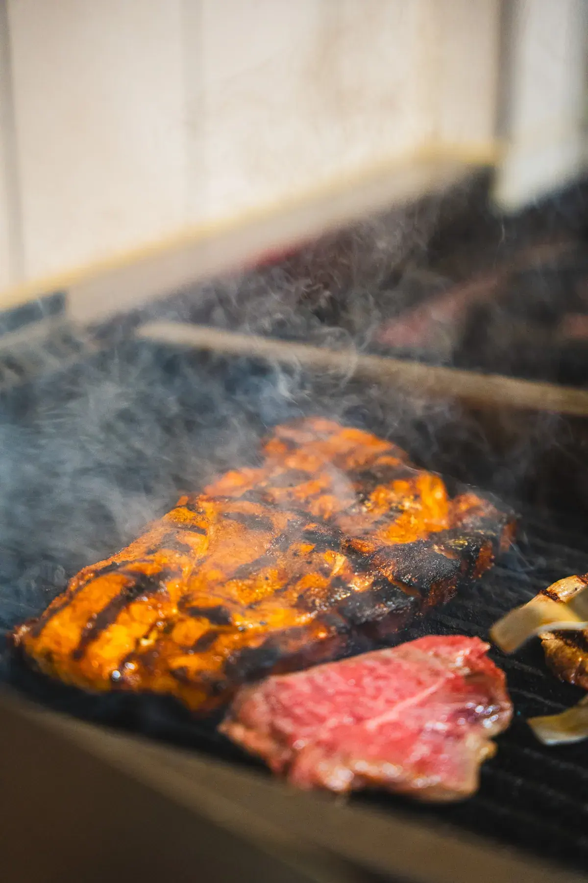 Steak und Rinderhüfte über rauchendem Grill