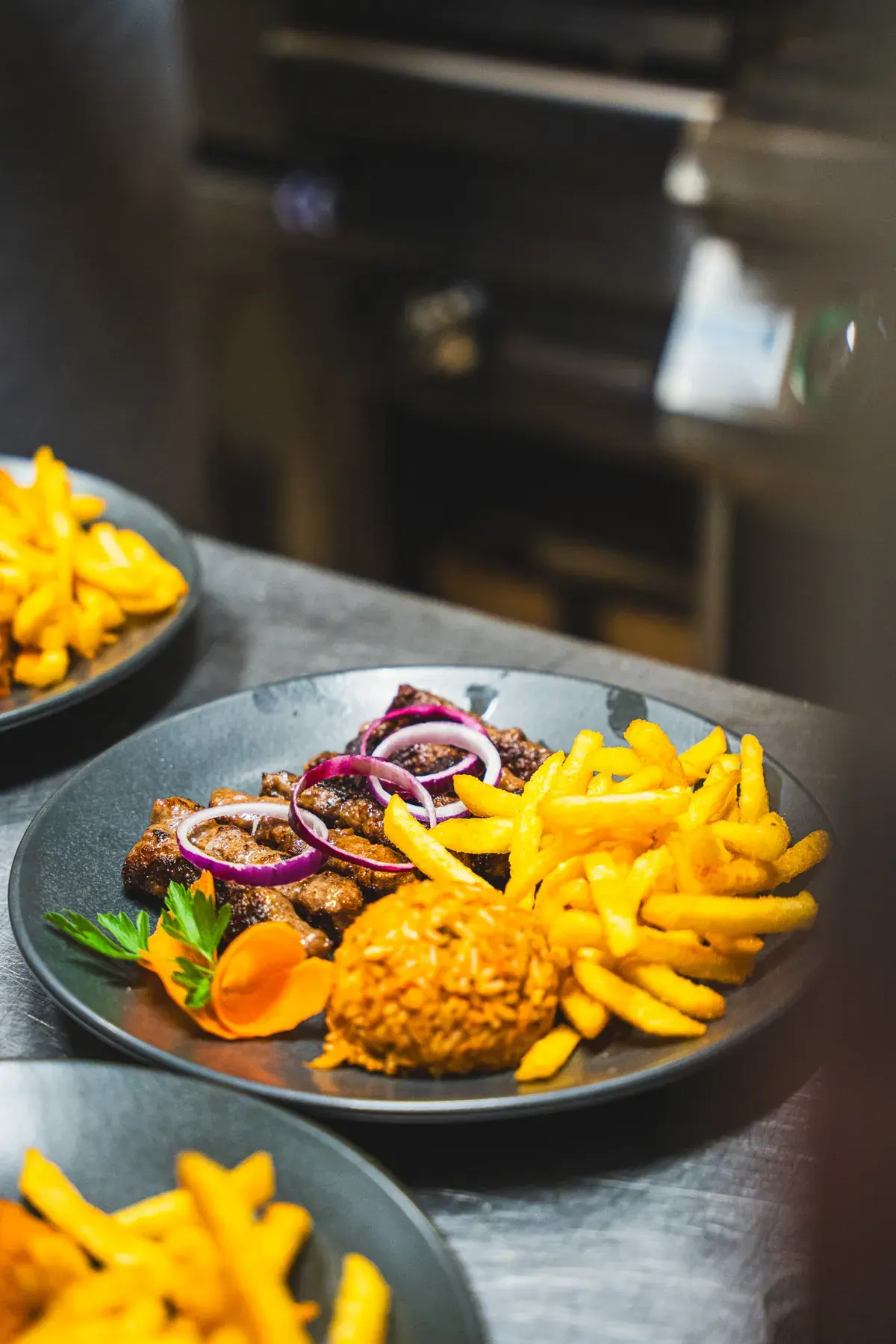 Cevapcici mit roten Zwiebeln, Pommes frites und Djuwetschreis